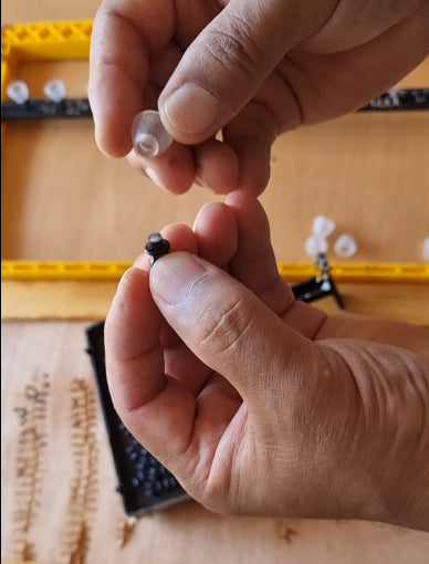 Hands holding components from the BEESTKEEPING Queen Rearing & Royal Jelly Kit for beekeeping.